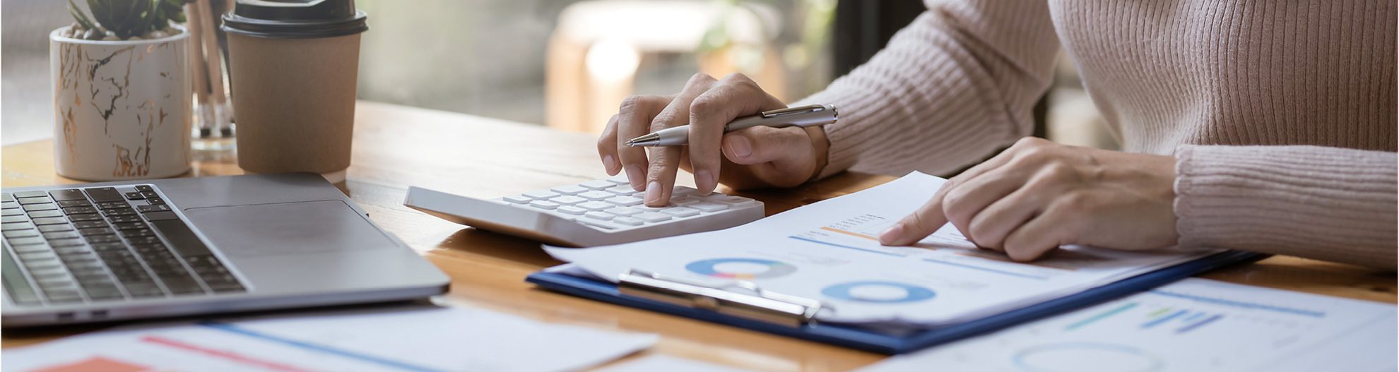Close-up image of business woman hands using a calculator to check finances